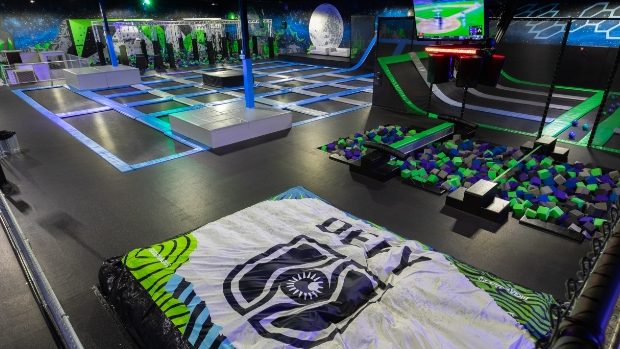 Interior view of Sky Zone trampoline park featuring colorful trampolines, a foam pit, and various activity areas.