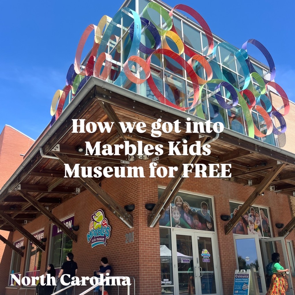 Exterior view of Marbles Kids Museum in North Carolina with colorful decorative elements on the building and a clear blue sky.