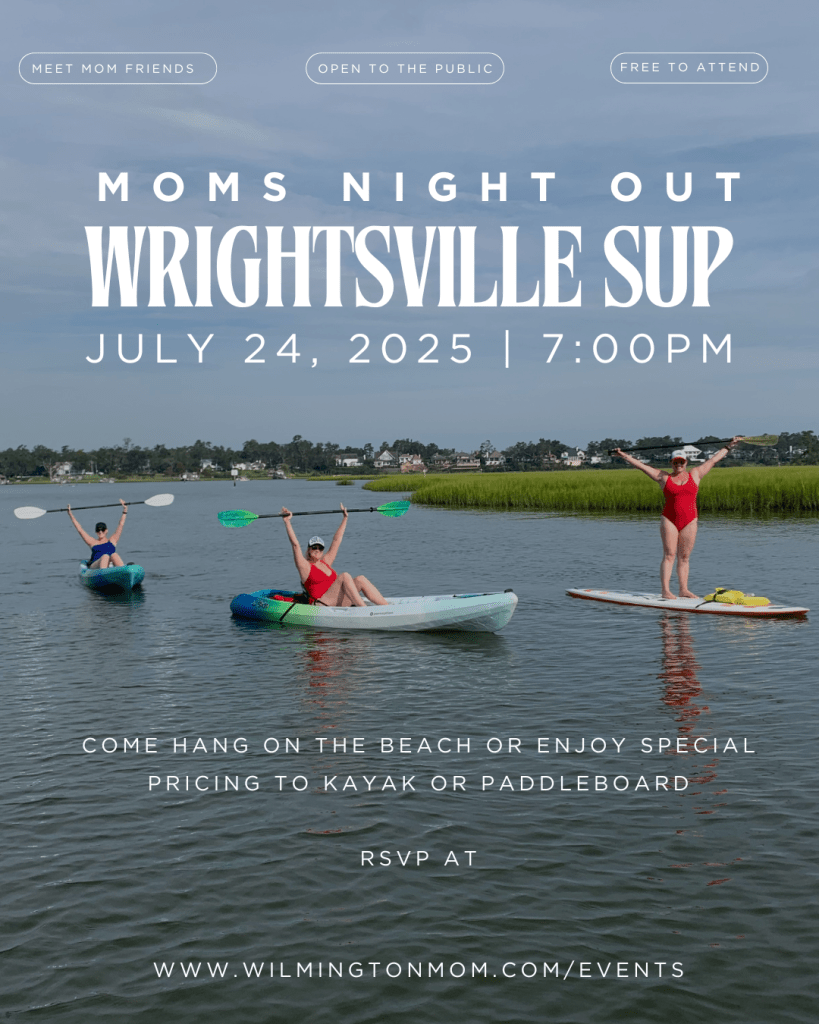 A scenic view of three women enjoying a 'Moms Night Out' event on the water in Wrightsville Beach, with two in kayaks and one on a paddleboard, surrounded by greenery and a peaceful atmosphere.